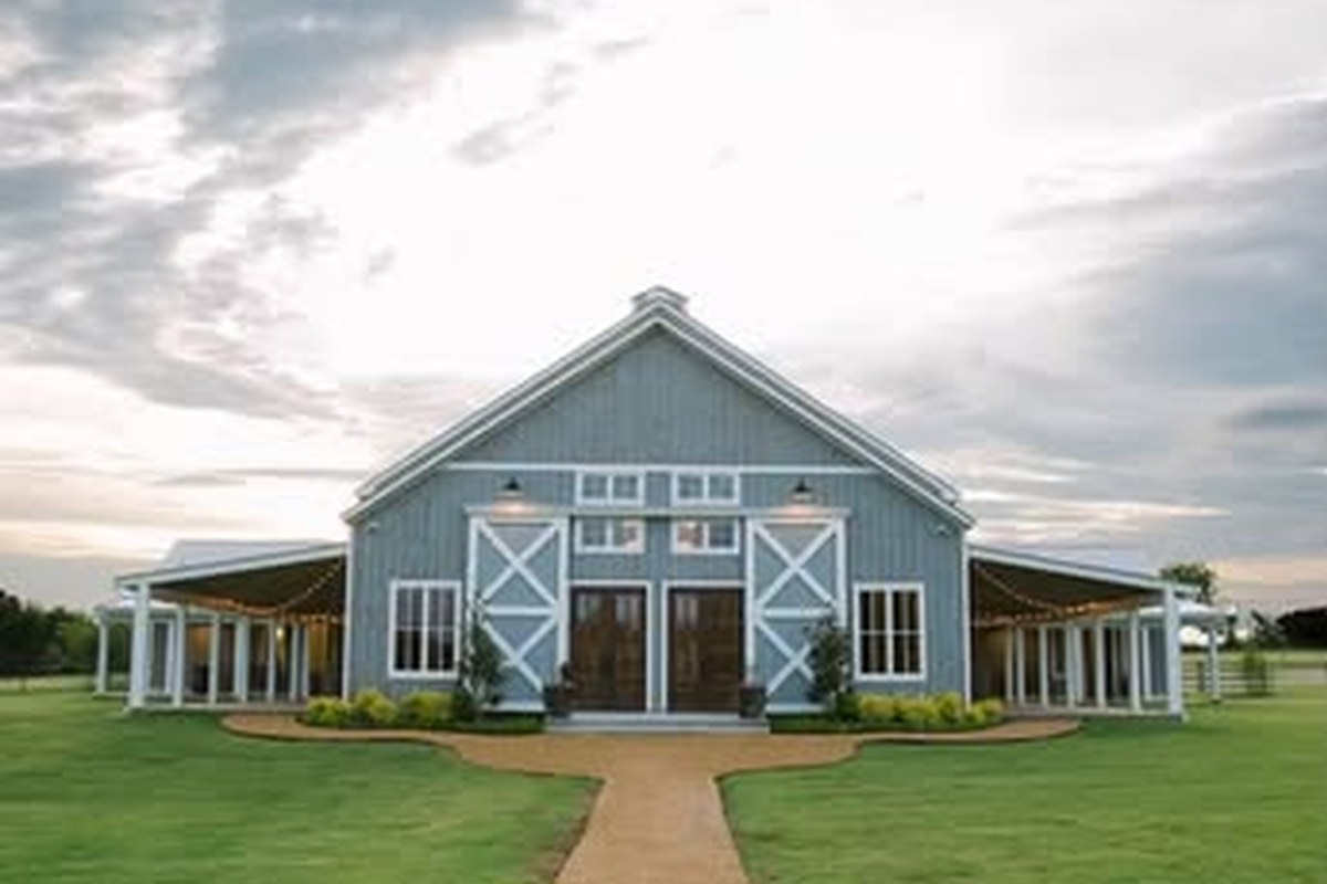 White and gray barn exterior of Bella Terra Venue Gunter Texas with gravel walkway