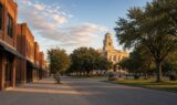 Golden-hour view of a quiet North Texas downtown street with brick storefronts and a courthouse tower, illustrating everyday Sherman, Texas.