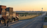 Gunter, Texas main street and highway corridor at sunrise, with distant construction on the horizon