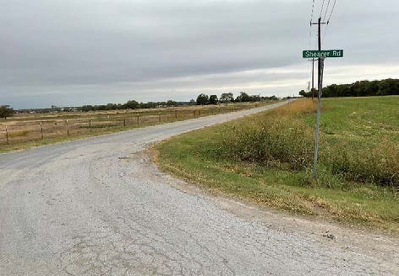 Lights Ranch Road facing north at the Shearer Road sign beside open pasture on the Bryson Ranch property in Pilot Point TX