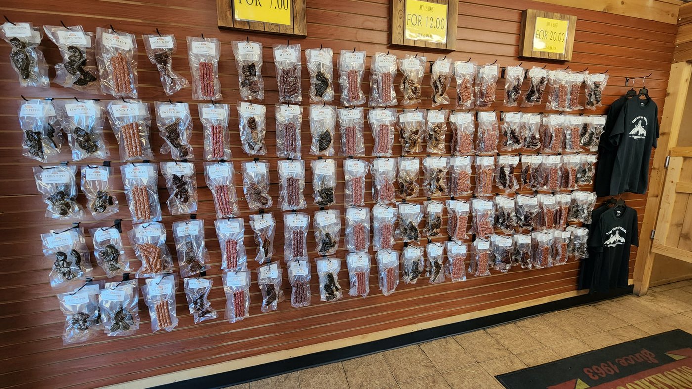Long wall of hanging jerky and snack stick bags inside Don's Smokehouse in Howe, TX