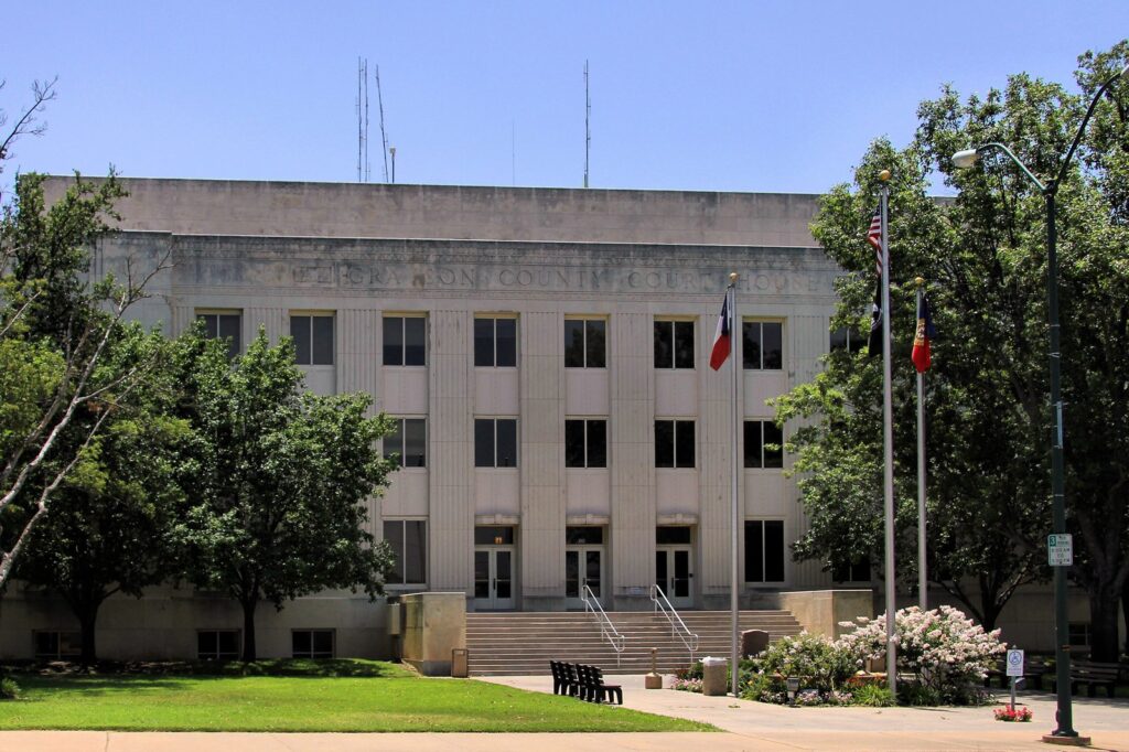 The Grayson County Courthouse in downtown Sherman, Texas, with Texas and U.S. flags