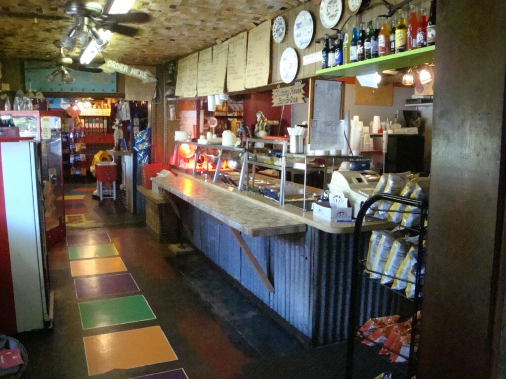 Cafeteria-style serving counter inside Hickory House Bar-B-Que Denison with a colorful tile floor and memorabilia on the walls