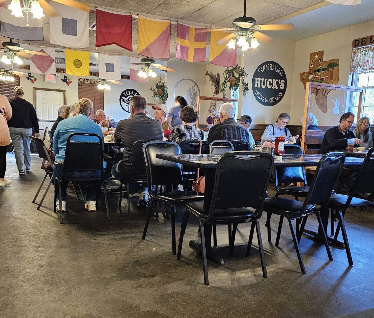 Busy dining room with Farm Raised Huck's Delta Goodness sign at Huck's Catfish Denison