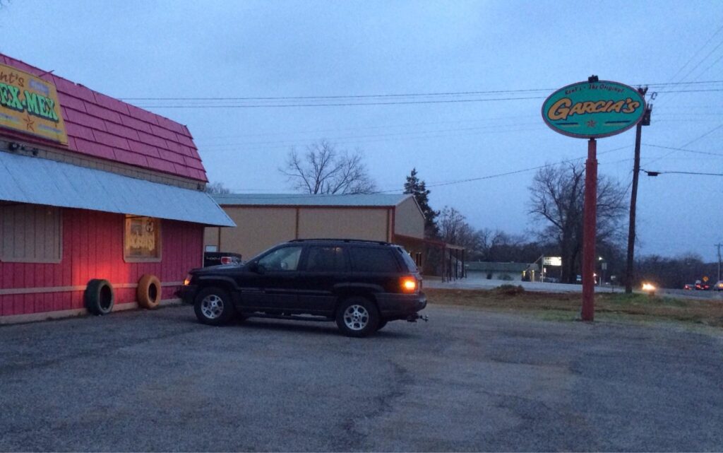 Kent's Tex-Mex Denison building with its red roof, parking lot, and oval pole sign on Woodlawn Boulevard