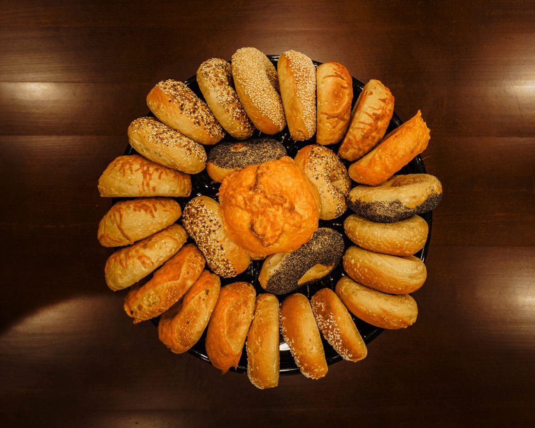 Round tray of assorted Legacy Bagels sourdough bagels, plain and seeded, seen from above