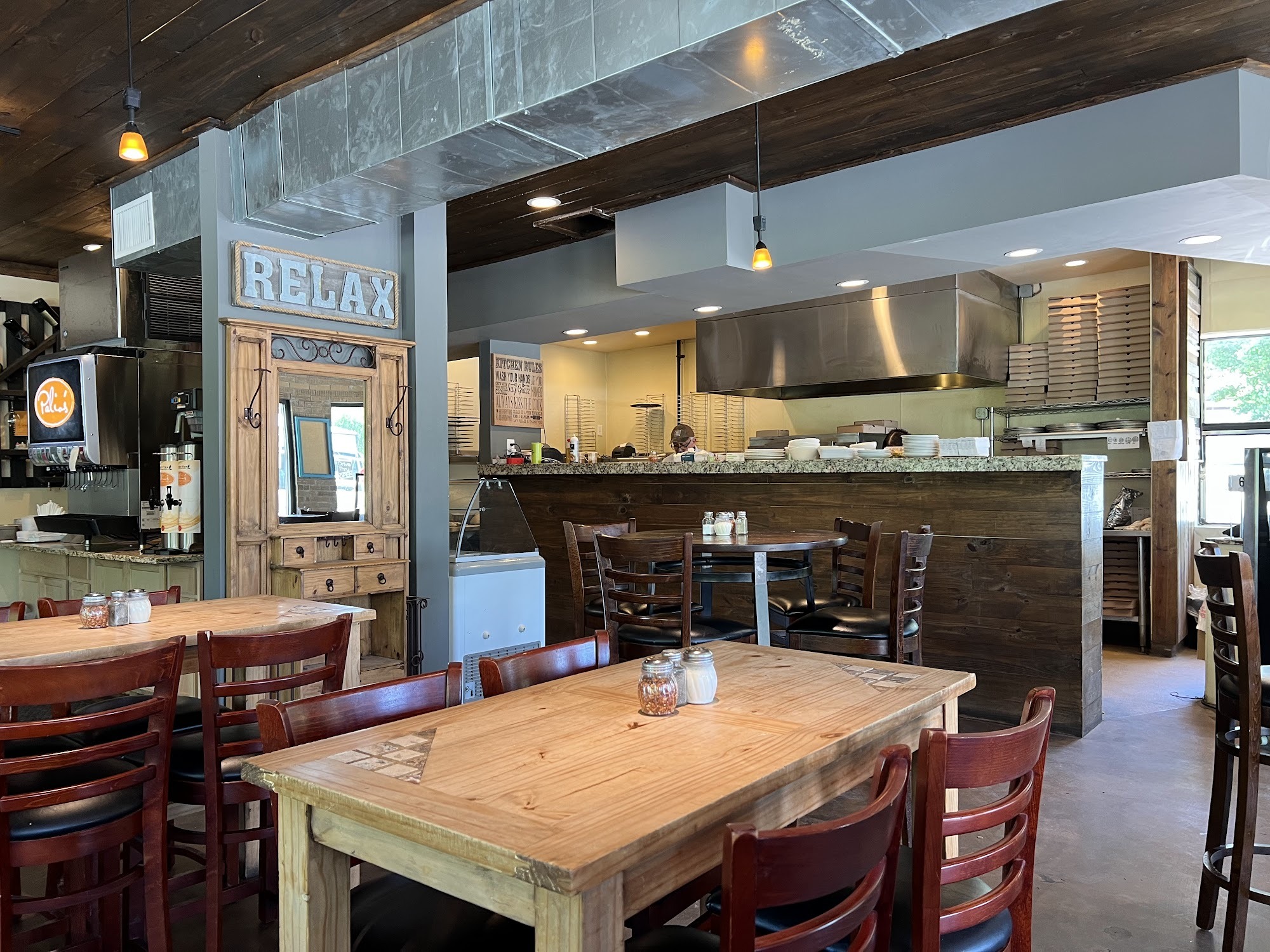 Dining room with wooden tables and red chairs at Palio's Pizza Cafe Howe