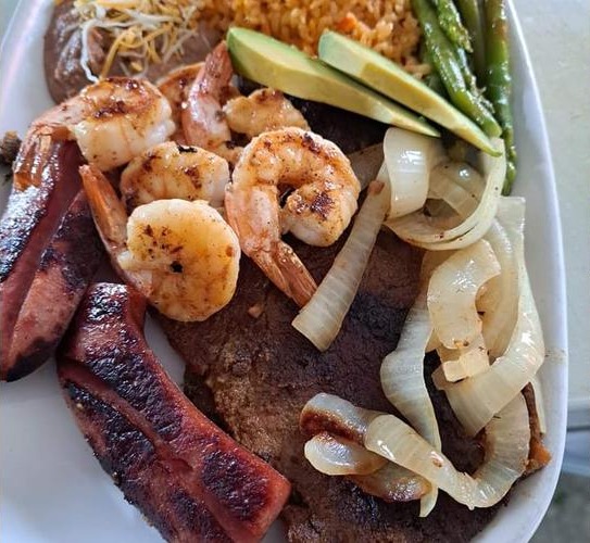 Grilled shrimp, steak, and sausage plate with rice, avocado, and grilled onions from Street Tacos in Howe