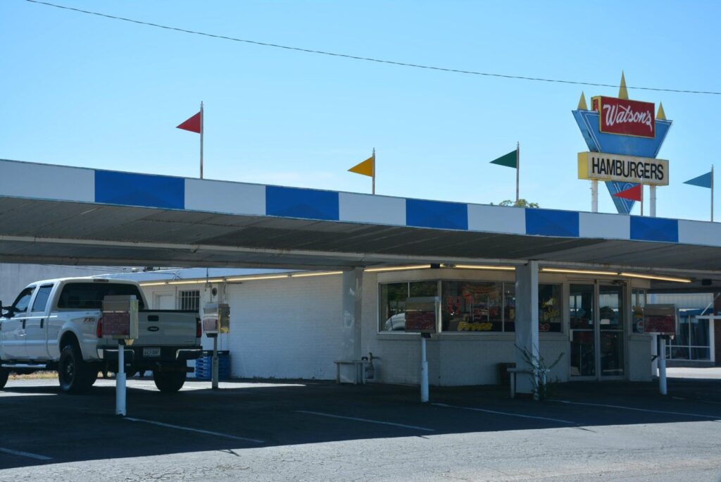 Blue-and-white carhop awning and order stalls at Watson's Drive In Denison on West Main Street